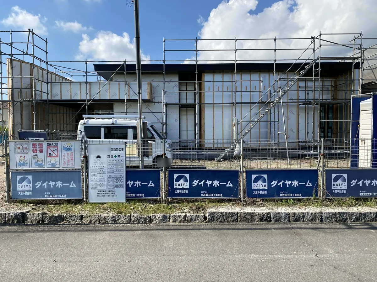 足場とダイヤホームの看板がかかる、建築中の平屋の昼間の様子
