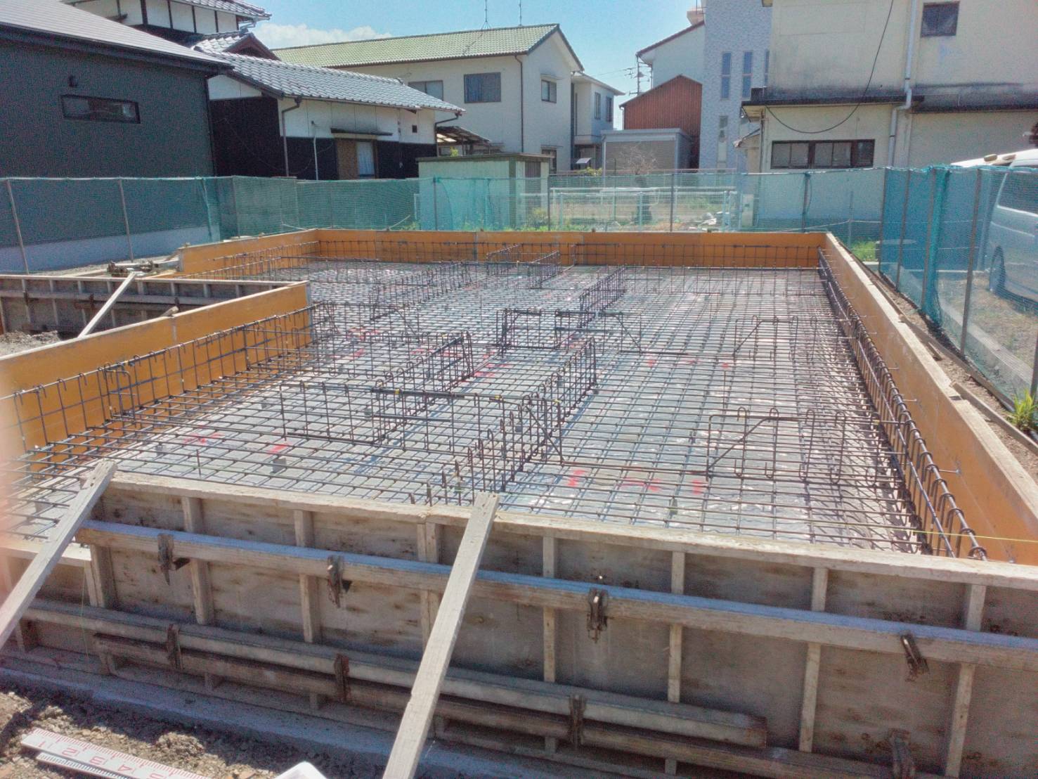 住宅の基礎工事の様子。ベタ基礎の配筋を組み、外周に型枠を立てた施工現場