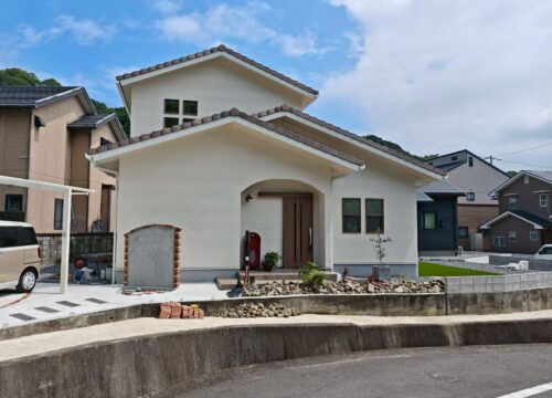 愛媛県四国中央市の南欧風2階建ての外観。瓦屋根と白い外壁、アーチの玄関ポーチのある新築注文住宅
