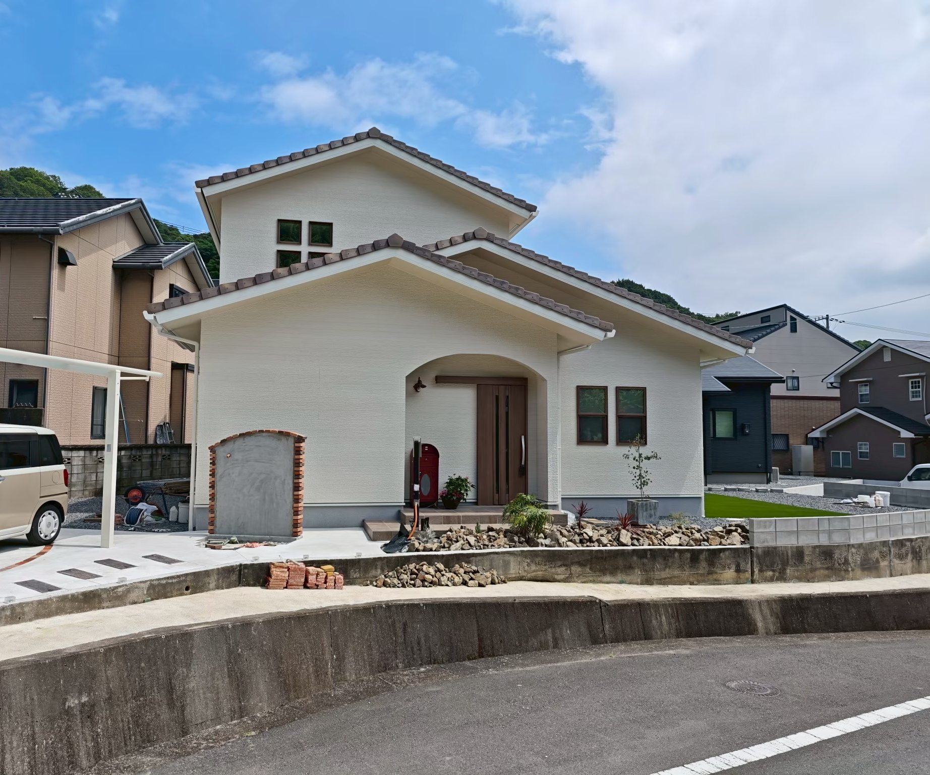 愛媛県四国中央市の南欧風2階建ての外観。瓦屋根と白い外壁、アーチの玄関ポーチのある新築注文住宅