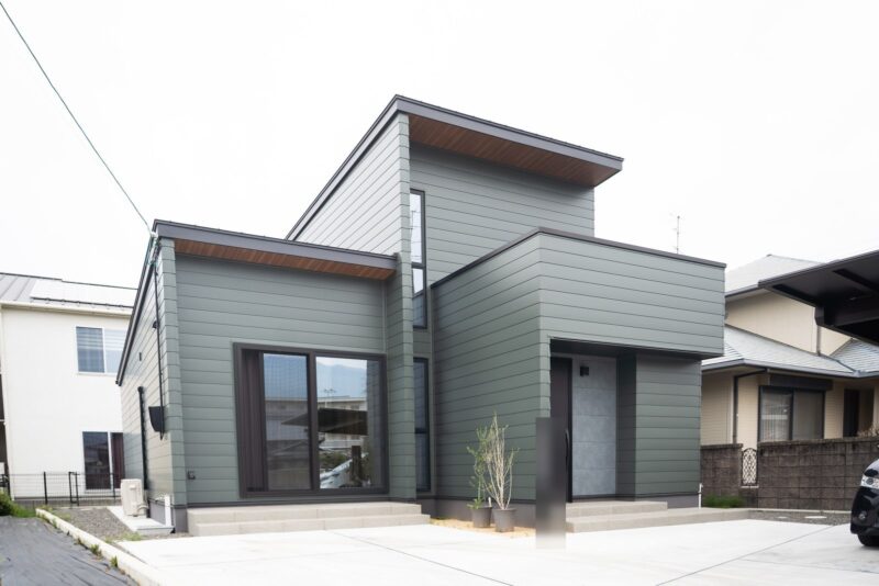 ガルバリウム鋼板の横張り外壁と片流れ屋根が重なる二階建て住宅の正面外観。西条市の注文住宅