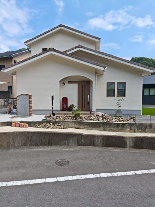 四国中央市の南欧風の家の外観。重なり合う瓦屋根とアーチの玄関ポーチが特徴の2階建て注文住宅