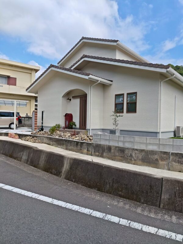 道路から見た四国中央市の南欧風住宅。段違いに重なる瓦屋根の新築2階建て注文住宅