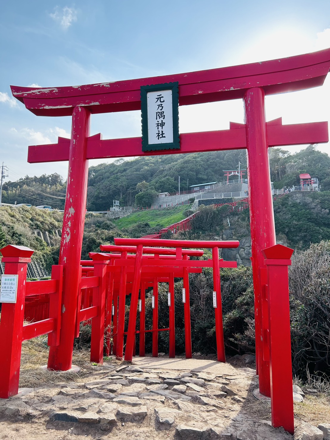 青空の下に立つ元乃隅神社の大鳥居と連なる赤い鳥居