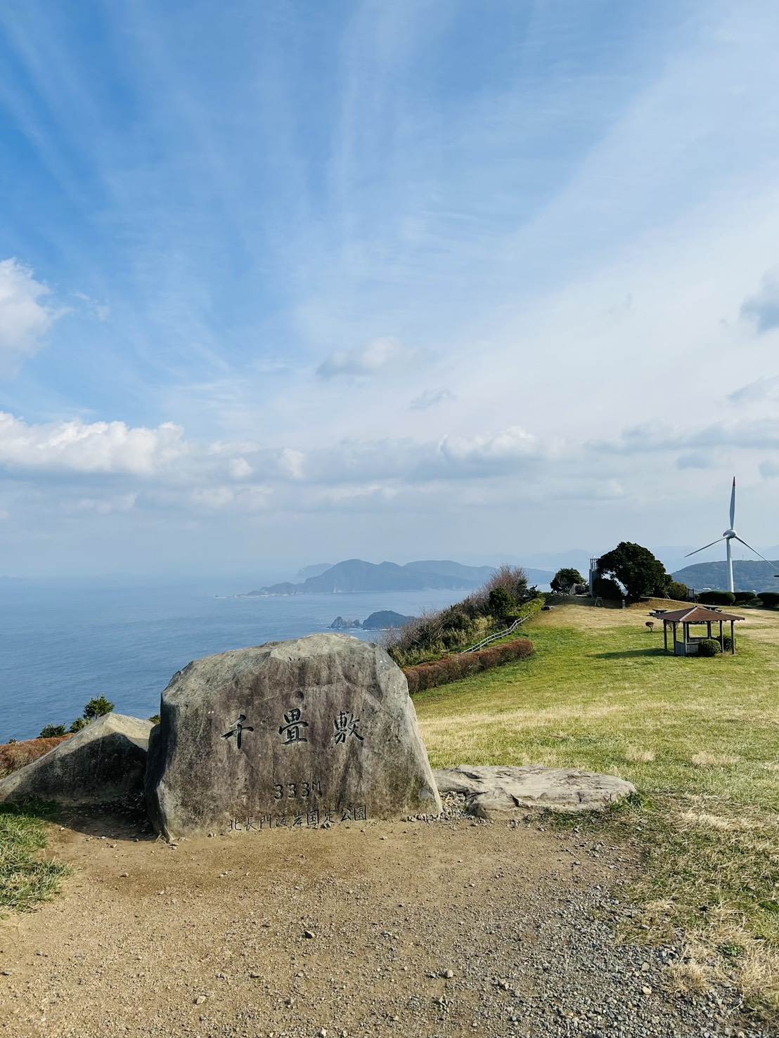 標高333メートルの石碑越しに日本海を望む長門市の千畳敷