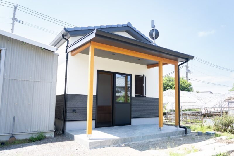 西条市の和風平屋のポーチ。化粧柱で大きな庇屋根を支え、掃き出し窓から土間へ直接出入りできるようにした