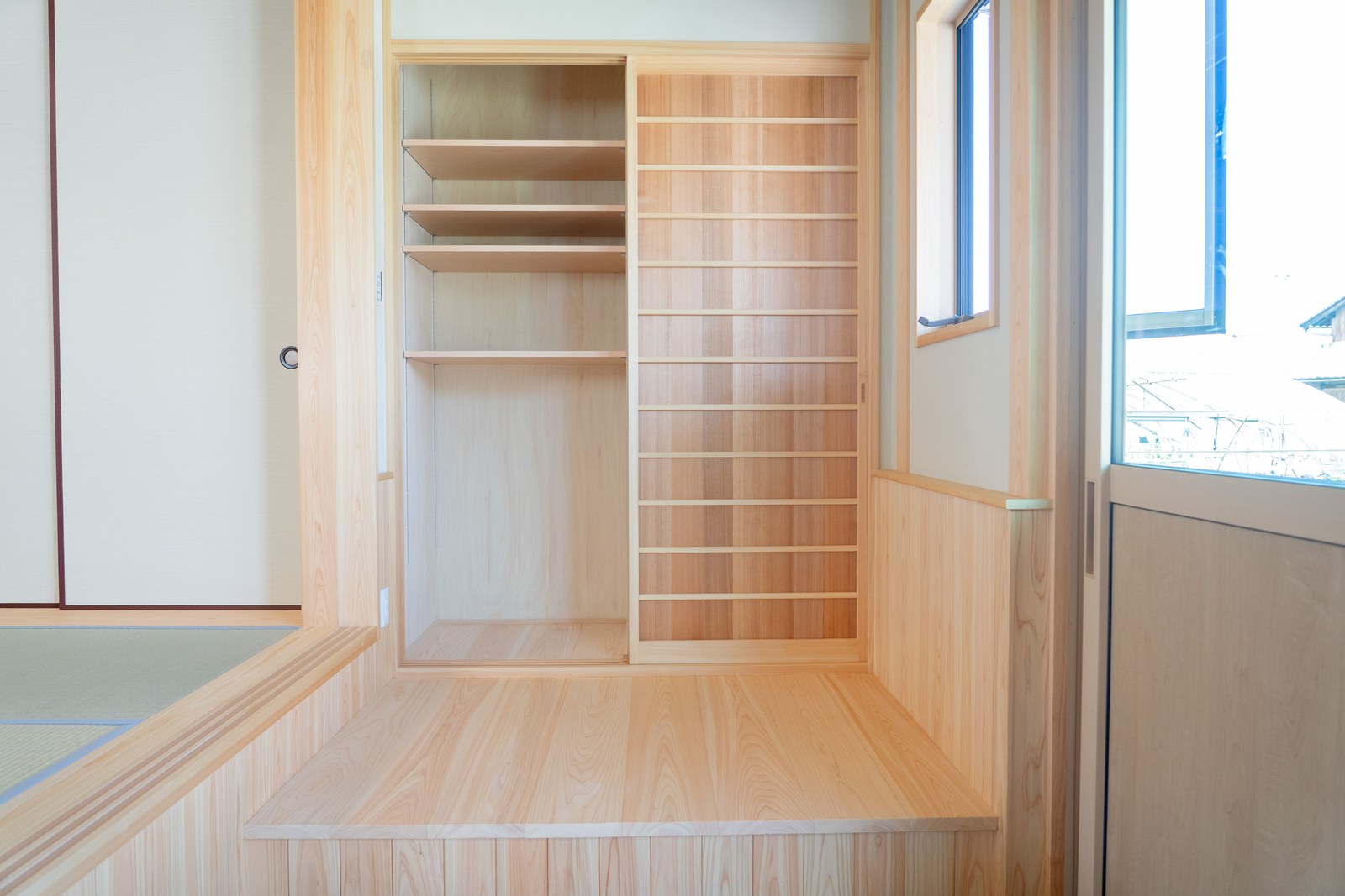 土間に造作した収納。桧の棚板を並べ、道具や外まわりのものをまとめて納められるようにした
