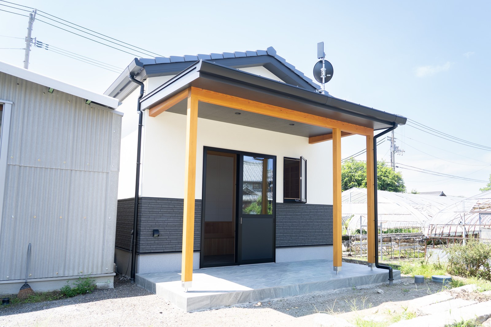 化粧柱で庇屋根を支えたポーチ。掃き出し窓から土間へ直接出入りでき、腰かけて庭を眺められる縁側のような場所